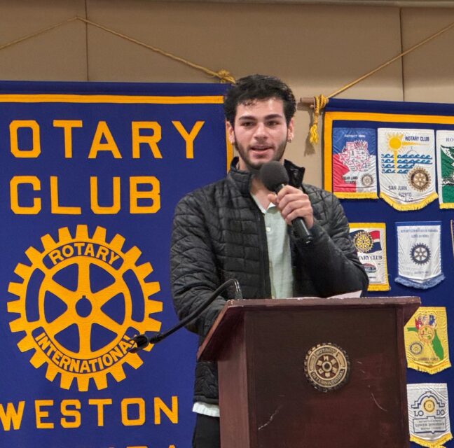 Student speaking at a Rotary Club of Weston meeting podium