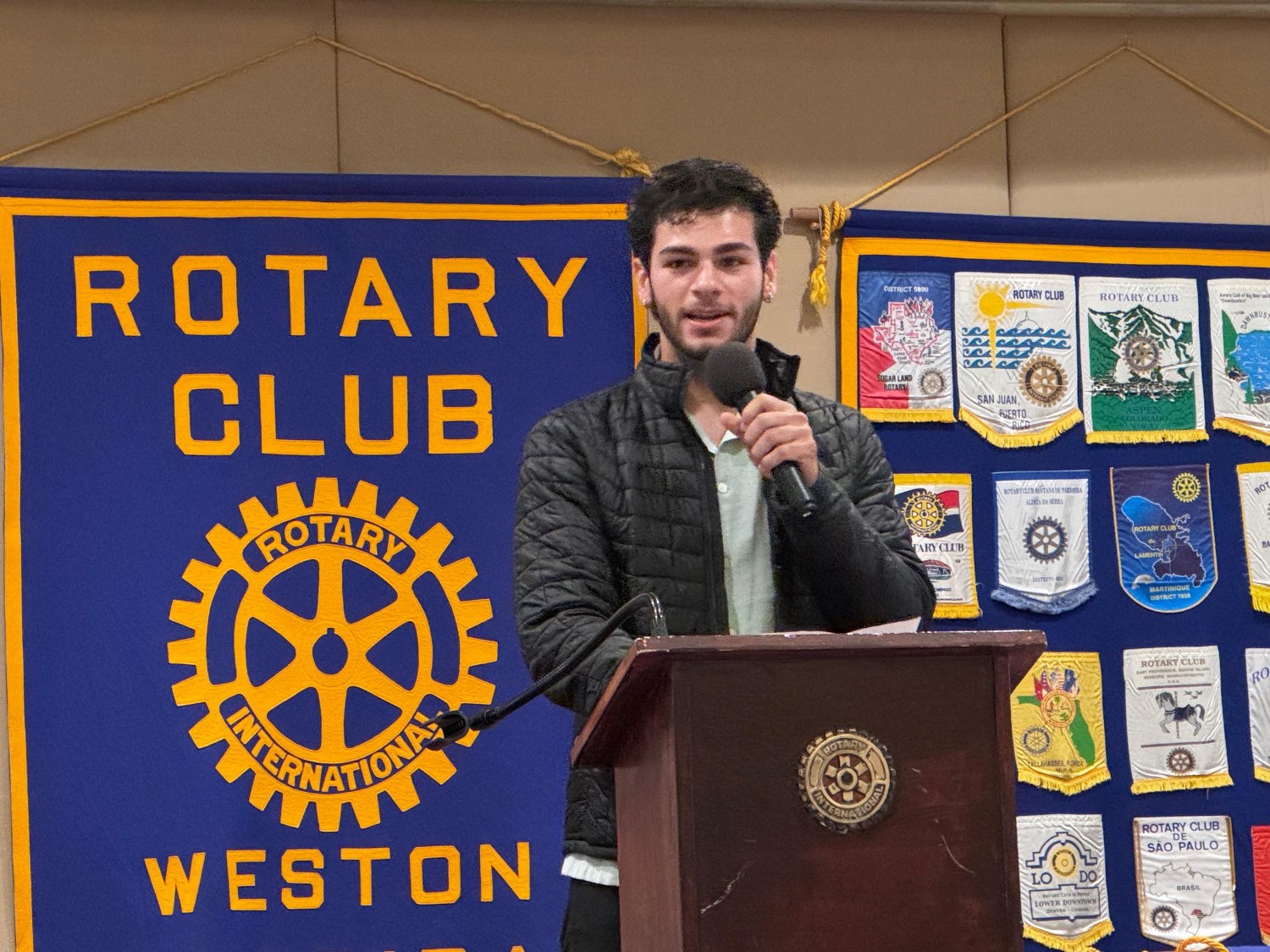 Student speaking at a Rotary Club of Weston meeting podium