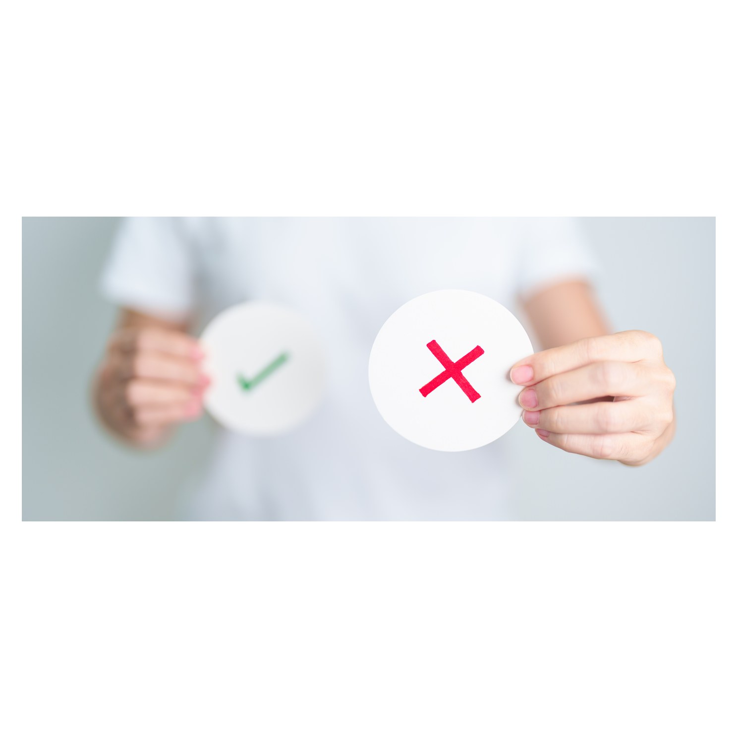 Hands holding a green check mark and a red X on paper circles